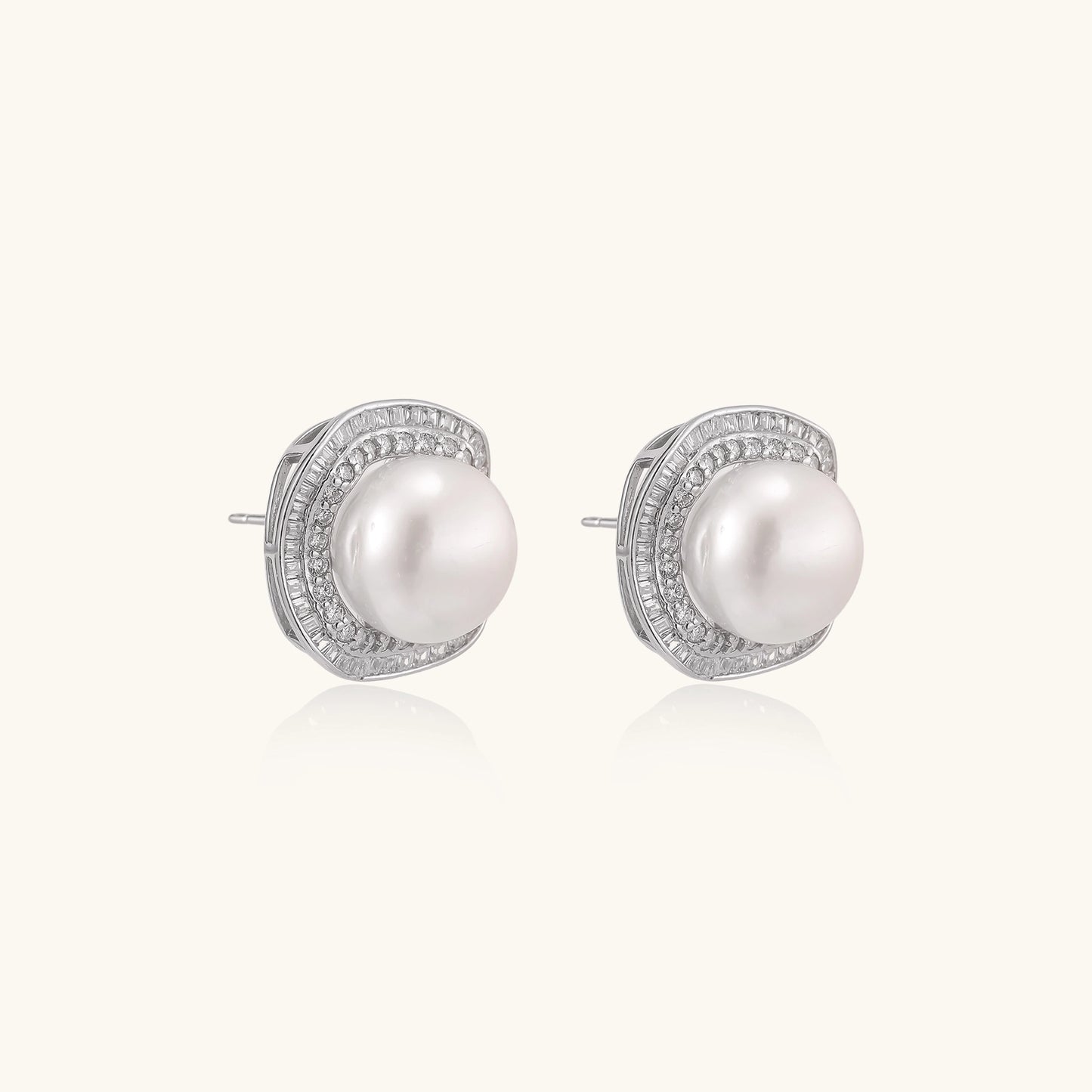 Sterling silver stud earrings with round freshwater pearls surrounded by sparkling crystal halos on white background.