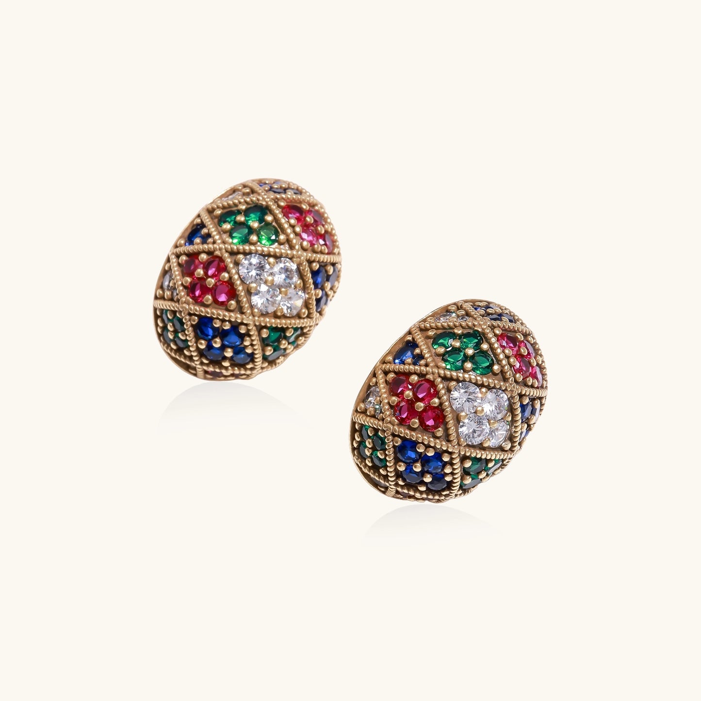 Oval gold-plated stud earrings with multicolor zirconia stones in geometric diamond pattern on white background.