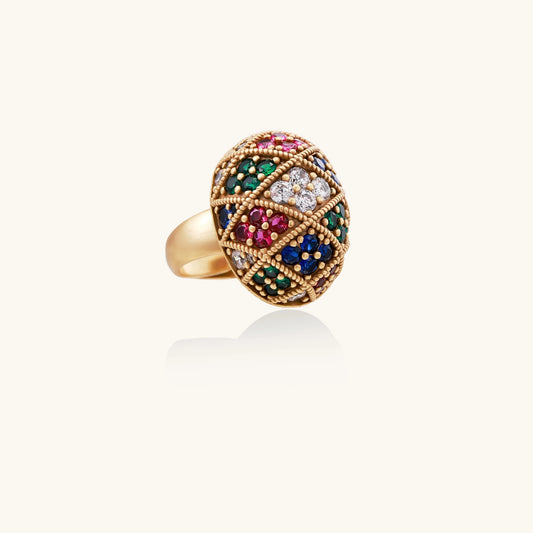 Domed gold-plated ring with geometric mosaic pattern featuring blue, green, red and clear zirconia stones in diamond settings
