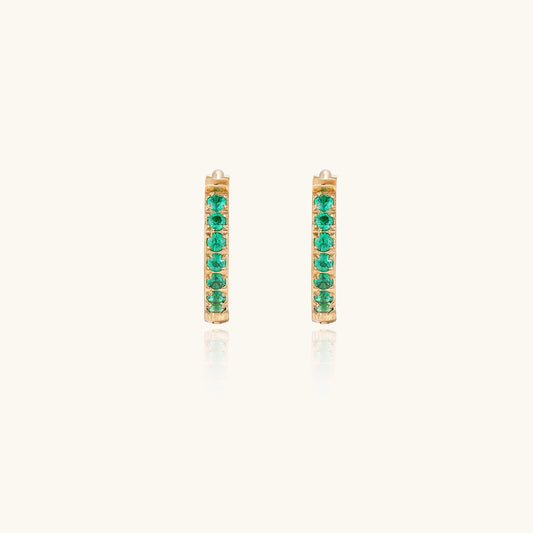 Small gold-plated huggie hoop earrings with emerald green cubic zirconia stones, one open showing hinge mechanism
