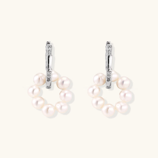 Sterling silver huggie hoop earrings with clustered white freshwater pearls and crystal accents on white background.