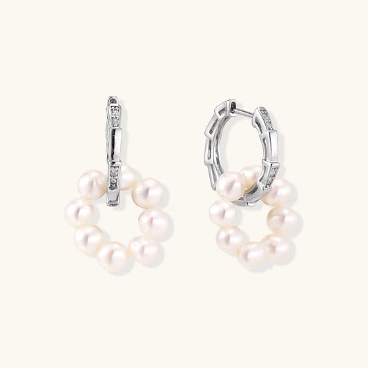 Sterling silver huggie hoop earrings with clustered white freshwater pearls and crystal accents on white background.