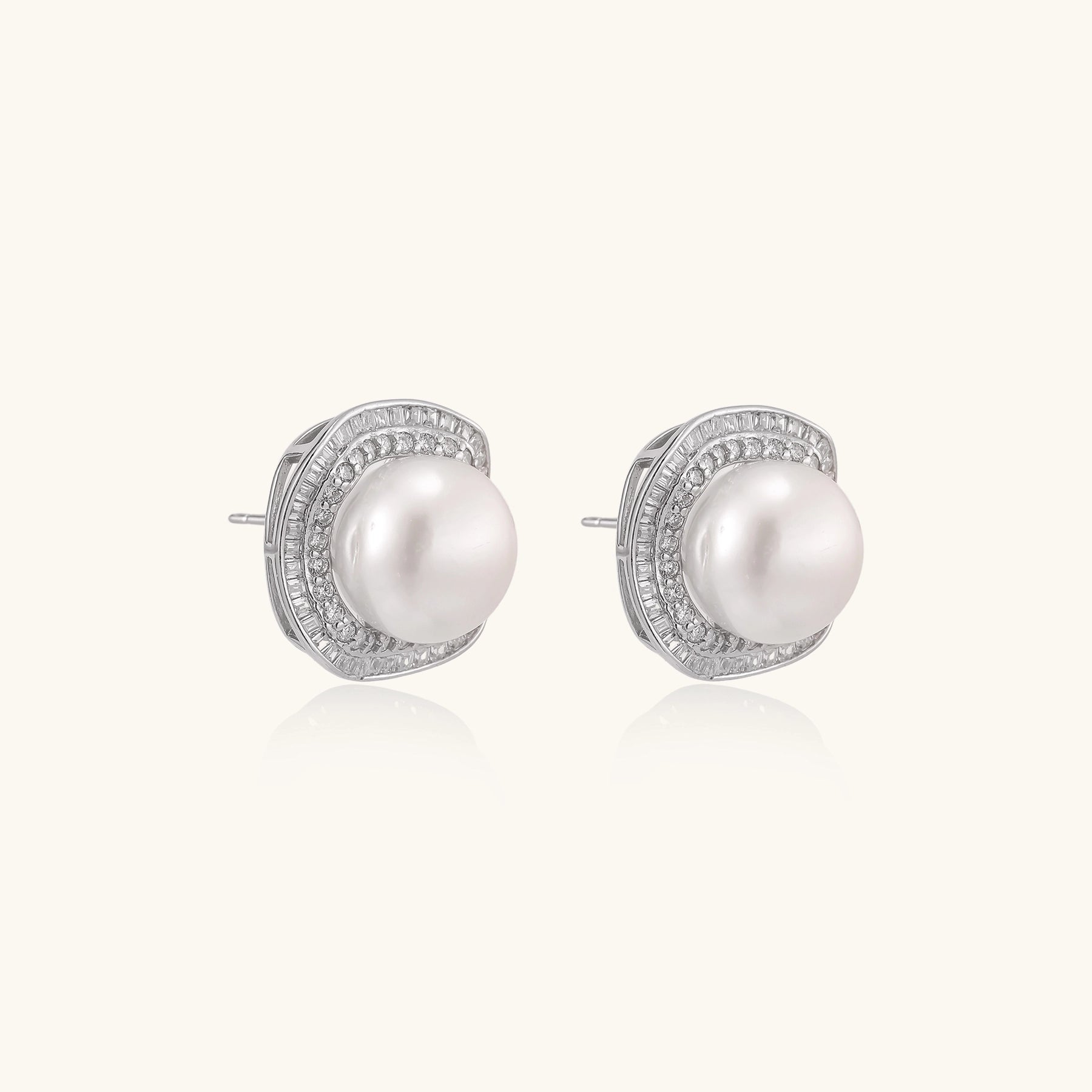 Sterling silver stud earrings with round freshwater pearls surrounded by sparkling crystal halos on white background.
